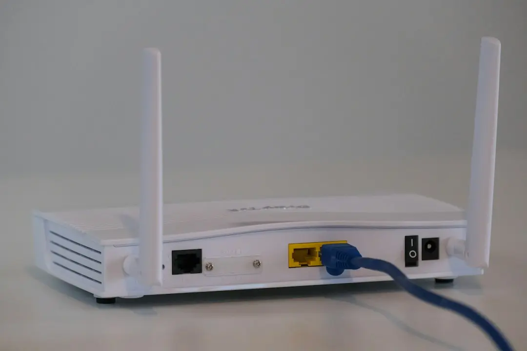 A white Wi-Fi router with a blue Ethernet cable plugged into its back, the first thing to check when TvNado stops working or buffers