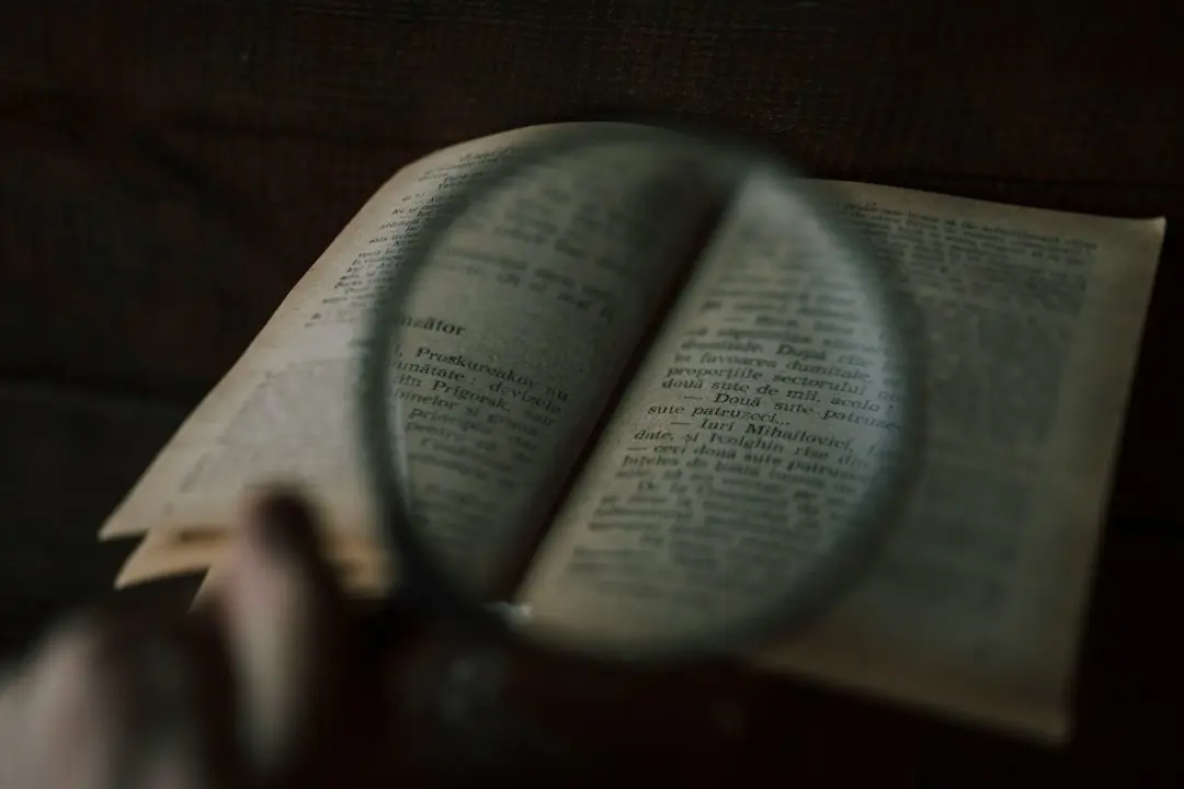 A magnifying glass resting on printed pages, a reminder to read the terms before trusting any IPTV review, TvNado included